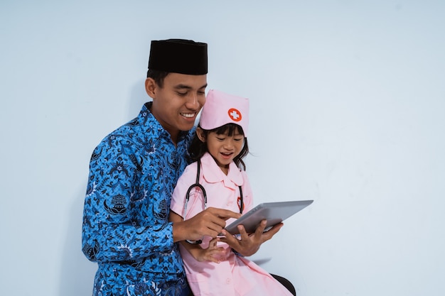 Jolie petite fille asiatique en uniforme de médecin avec son père