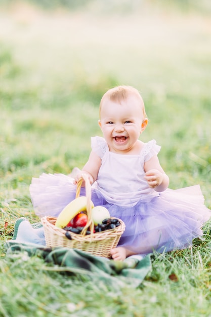 Jolie petite fille assise sur l'herbe par une journée ensoleillée