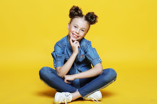 Jolie petite fille assise et souriante