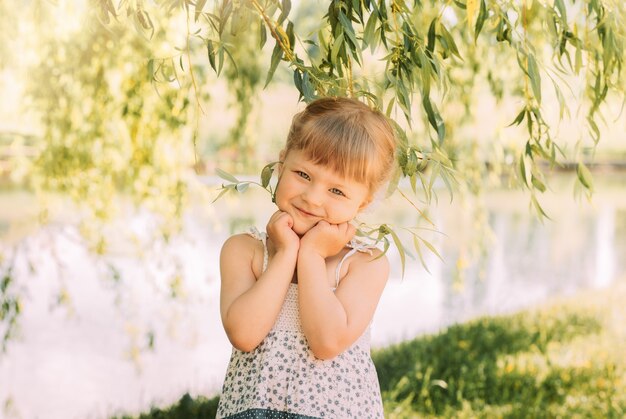 Jolie petite fille au bord de la rivière en été