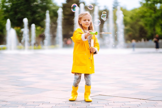 Jolie petite fille en automne lors d'une promenade soufflant des bulles de savon Concept de mode de vie de repos actif de l'enfance.