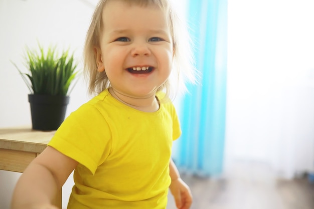 Jolie petite fille en bas âge s'amusant à tenir un pot avec une fleur plantée à la maison. Concept de soins aux fleurs et à la nature. Enfants et famille enfance heureuse.