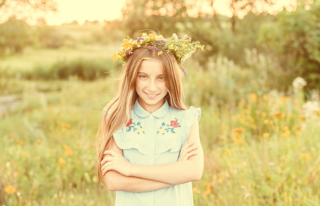 Jolie petite fille dans une couronne de fleurs