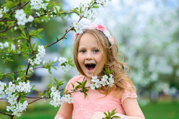 Jolie petite fille dans un jardin fleuri