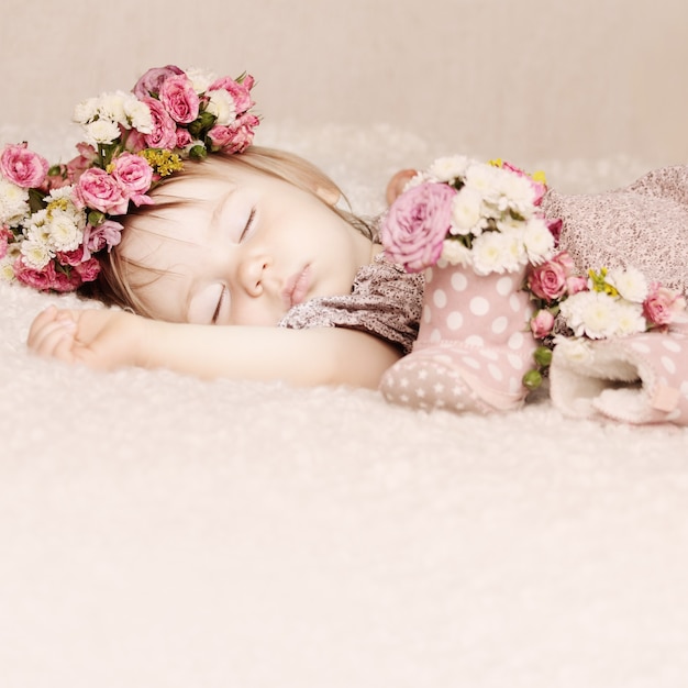 Jolie petite fille dort avec des fleurs