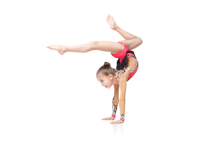 Photo jolie petite fille faisant de la gymnastique avec un ballon sur fond blanc