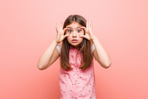 Jolie petite fille en gardant les yeux ouverts pour trouver une occasion de réussir.