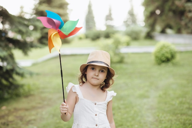 Jolie petite fille heureuse dans un chapeau s'amusant dans la prairie du parc Pique-nique sur la nature
