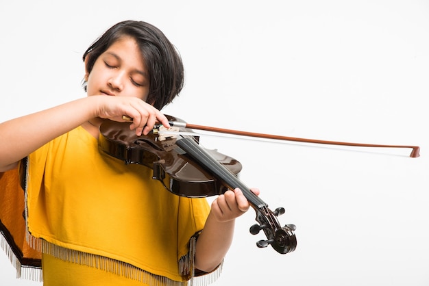 Jolie petite fille indienne ou asiatique jouant du violon, isolée sur fond blanc