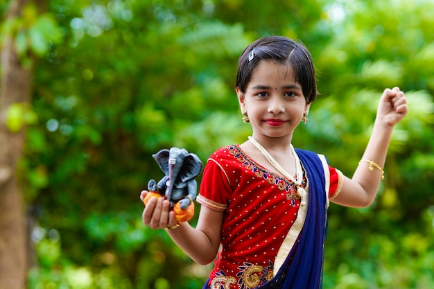 Jolie petite fille indienne célébrant le festival du seigneur ganesha