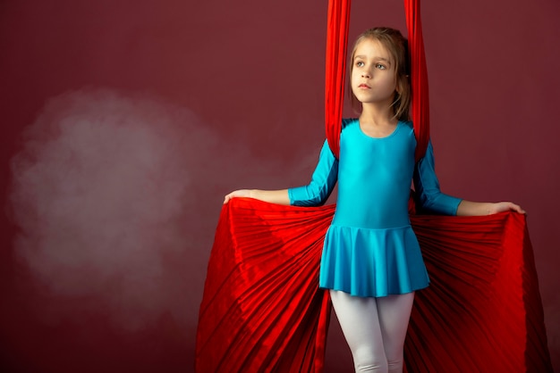 Jolie petite fille intrépide dans un costume de gymnastique bleu