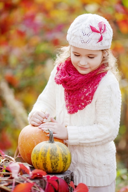 Jolie petite fille jouant avec des citrouilles en automne parc. Activités d'automne pour les enfants