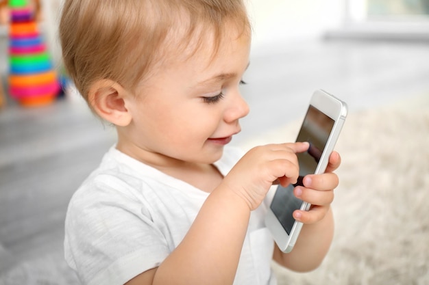 Photo jolie petite fille jouant avec un smartphone