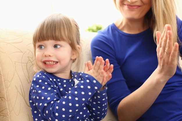 Jolie petite fille joue avec maman et tape dans les mains