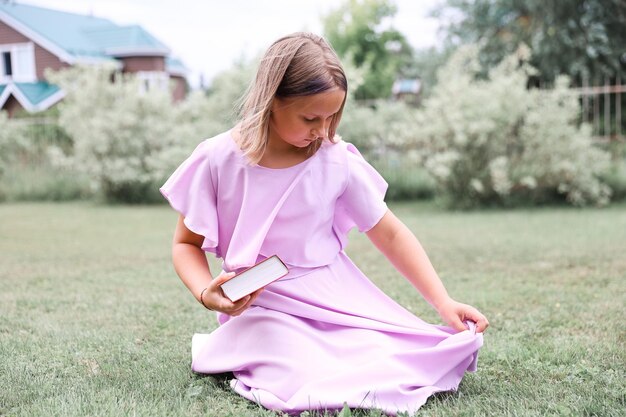 Jolie petite fille lisant un livre à l'extérieur. Repos d'été