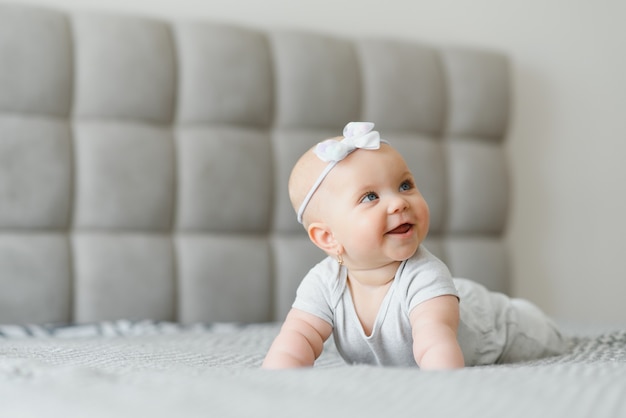 Photo une jolie petite fille sur le lit à la maison