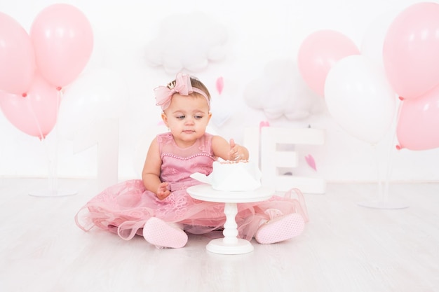 jolie petite fille mangeant un gâteau d'anniversaire et célébrant son premier anniversaire
