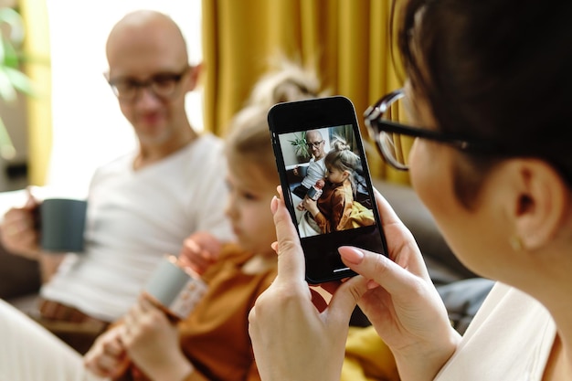 Jolie petite fille avec un microphone karaoké chantant pour ses parents à la maison