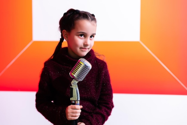 Photo jolie petite fille avec le microphone à la main.