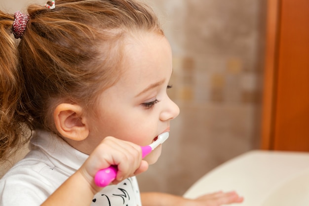 Jolie petite fille, nettoyage des dents avec une brosse.