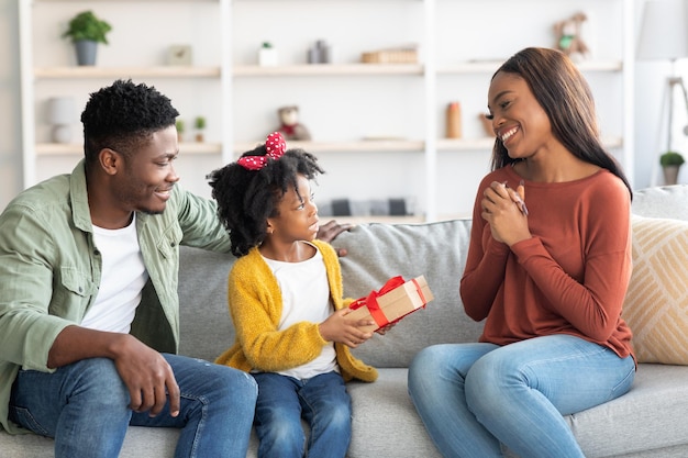 Jolie petite fille noire faisant une surprise à sa mère à la maison