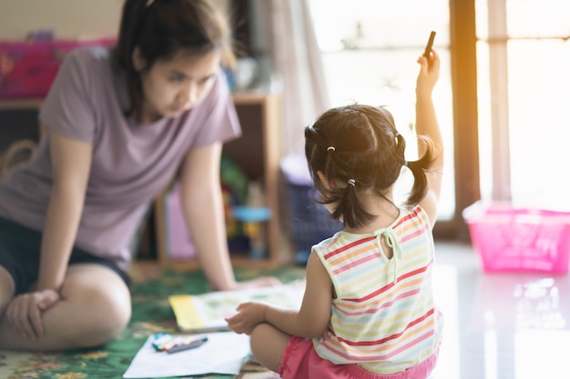 Jolie petite fille peignant avec sa mère à la maison