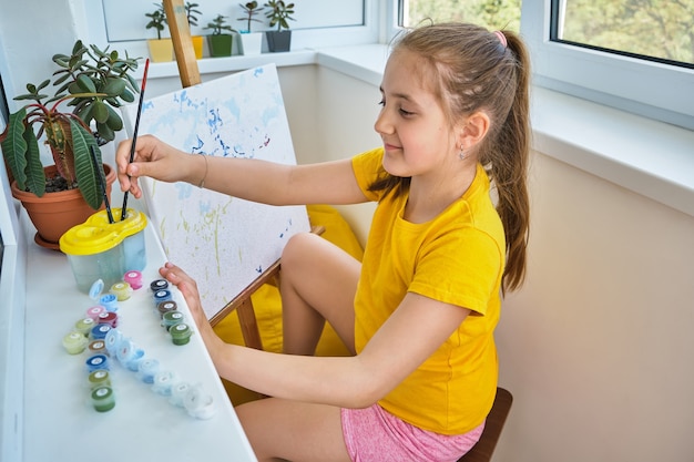 Jolie petite fille peinture sur toile. La créativité des enfants.