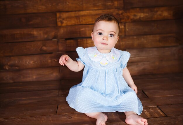 Une Jolie Petite Fille De 8 Mois Se Trouve Sur Le Plancher En Bois De La  Maison En Jouant Avec Des Jouets De Développement En Bois. Photo De Haute  Qualité