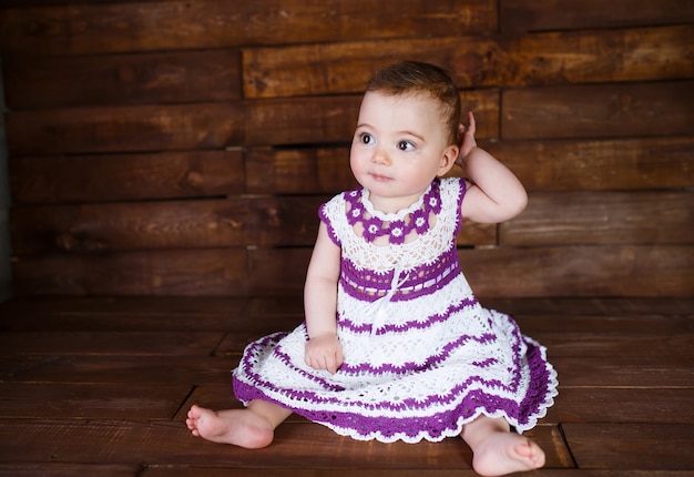 Jolie petite fille sur un plancher en bois.