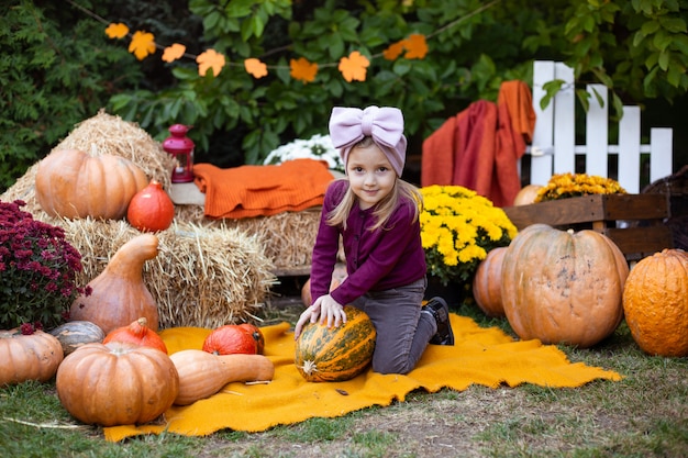 Jolie petite fille, profitant de la fête de la récolte avec les citrouilles