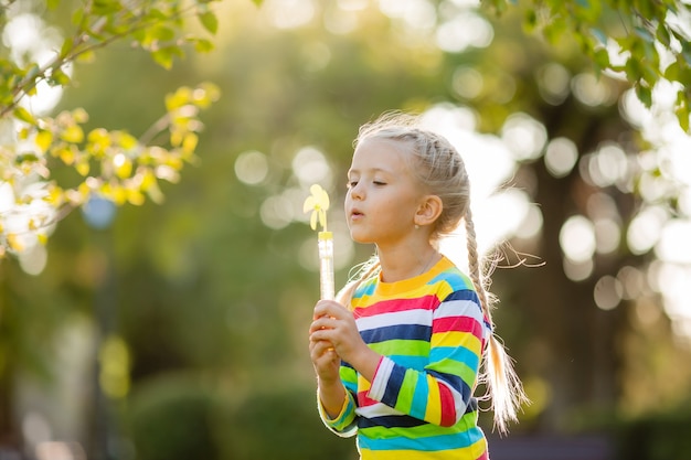 Jolie petite fille en promenade dans un chemisier tricoté multicolore