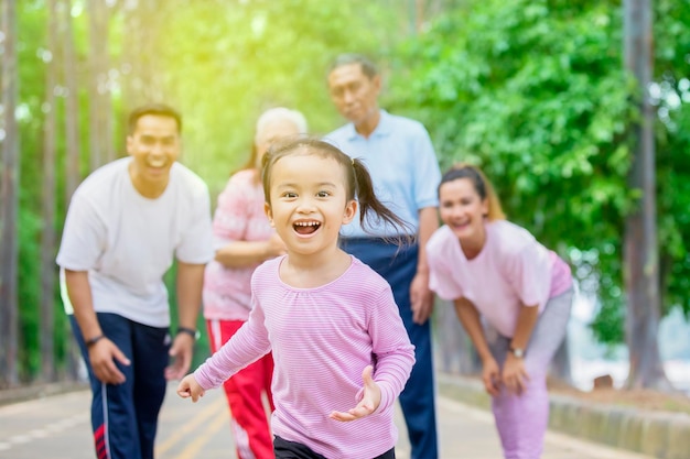 Jolie petite fille qui court dans la rue avec sa famille