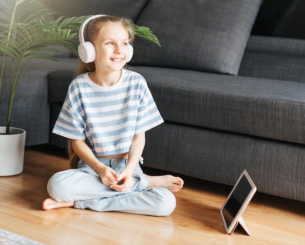 Une jolie petite fille qui écoute de la musique avec des écouteurs.