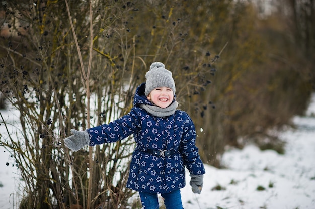 Jolie petite fille s'amusant à l'extérieur le jour de l'hiver.