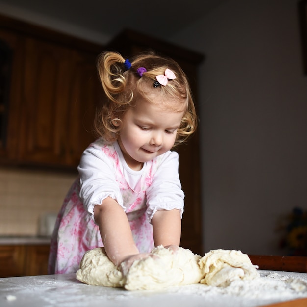 Jolie petite fille s'amusant pétrit la pâte