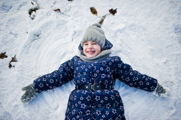 Jolie petite fille s'amuser à l'extérieur le jour de l'hiver.