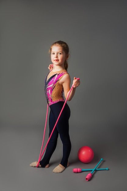 La jolie petite fille s'entraîne dans un uniforme de sport lumineux