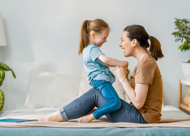 Une jolie petite fille et sa mère profitent d'une matinée ensoleillée. Bon moment à la maison.