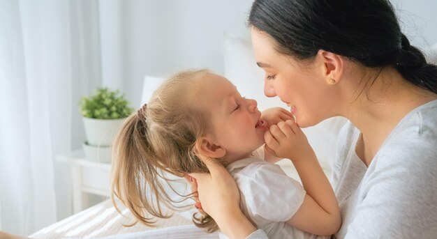 Une jolie petite fille et sa mère profitent d'une matinée ensoleillée. Bon moment à la maison.