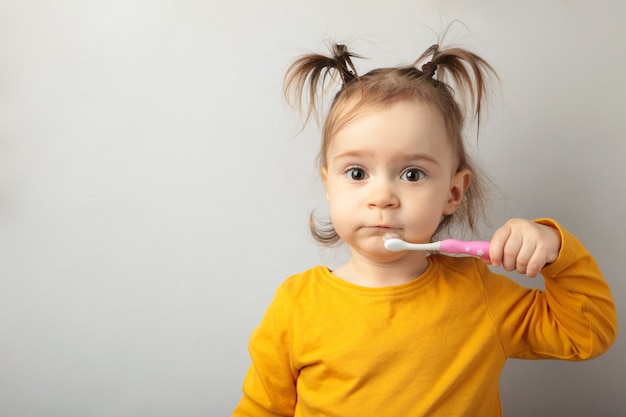 Jolie petite fille se brosser les dents. Vue de dessus