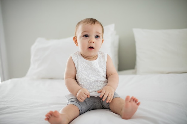 Jolie petite fille se détendre sur le lit dans la chambre