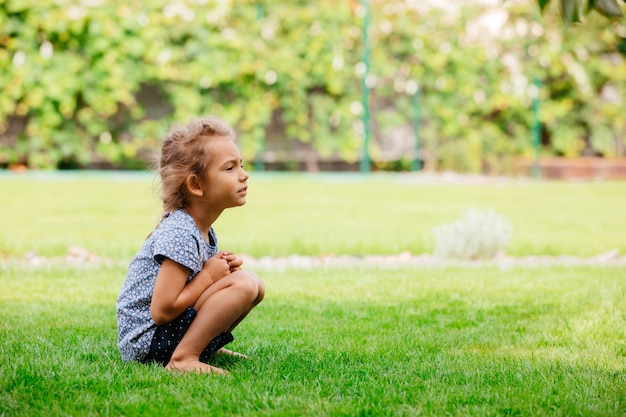 La jolie petite fille se repose seule dans l'arrière-cour