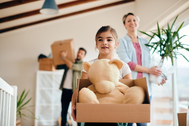 Jolie petite fille et ses parents emménageant dans une nouvelle maison