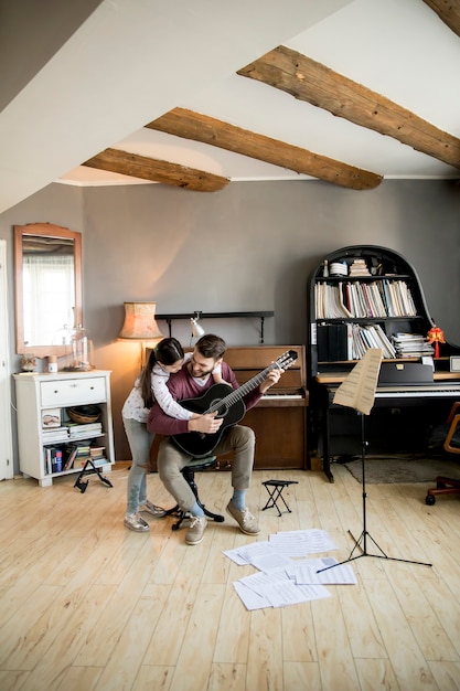 Jolie petite fille et son beau père jouent de la guitare