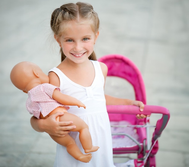 Une jolie petite fille avec son chariot de jouets