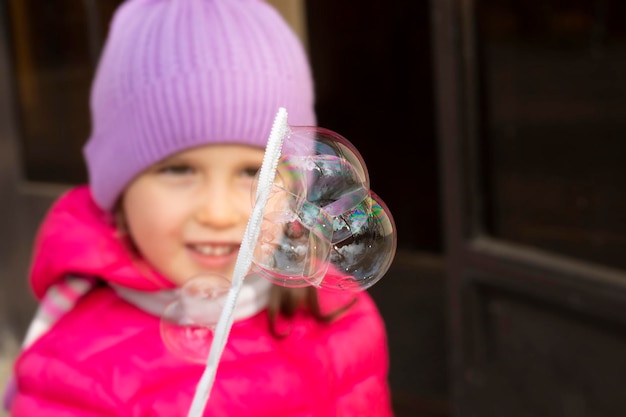 Jolie petite fille soufflant des bulles de savon