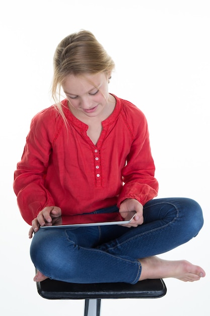 Jolie petite fille souriante à l'aide d'une tablette