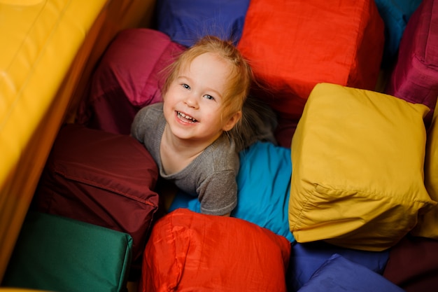 Jolie petite fille souriante jouant dans la salle de jeux