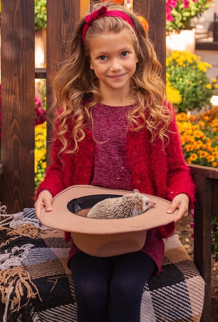 jolie petite fille tenant un hérisson dans ses bras portrait d'automne