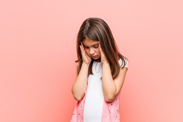 Jolie petite fille touchant les tempes et ayant mal à la tête